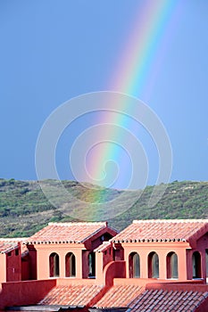 Colourful rainbow falling on building after storm