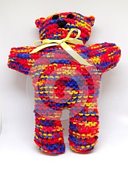 Colourful rainbow knitted teddy bear with ribbon scarf