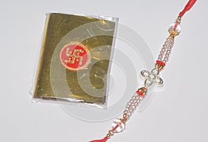 A colourful Rakhi and a golden packet