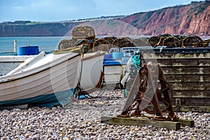 Colourful scene of a working beach with fishing boats and lobster pots at Burleigh Salterton