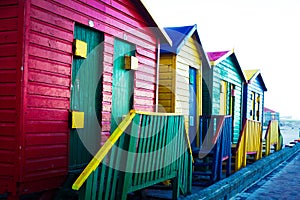 Colourful seaside cabins in late afternoon light