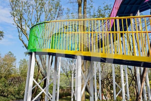 Colourful steel footbridge spiralling up in blue sky of sunny wi