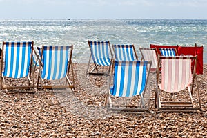 Colourful striped deck chairs on Brighton beach, England