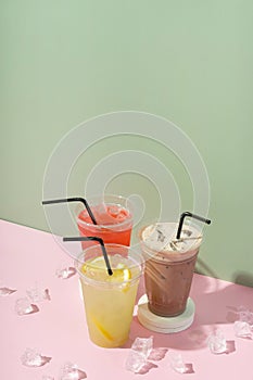 Colourful summer drinks with ice. Lemonades and milk shake on coloured background