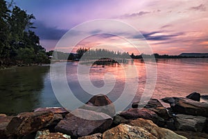 colourful sunrise over water from rocks on phu quoc in vietnam