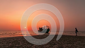 Colourful sunset behind the boat at the beach in Thailand