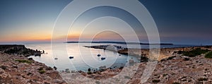 A colourful sunset over the cliffs of Paradis bay in Malta with a view on the Island of Gozo in the Mediterranean Sea.