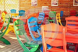 Colourful table and chairs ready for a cafe or restaurant. Summer terrace cafe, plastic colorful multi colored chairs outside. Co