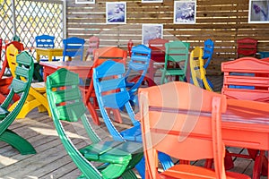 Colourful table and chairs ready for a cafe or restaurant. Summer terrace cafe, plastic colorful multi colored chairs outside. Co