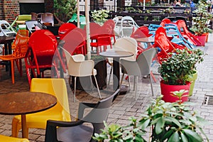 Colourful tables and chairs in a cafe. Yellow, blue, red colors. European restaurant in the city