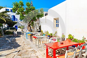 Colourful tables of a small bar on narrow street of Mykonos town, Mykonos island, Greece