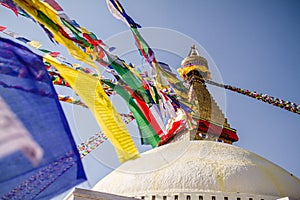 Colourful tibetan prayer flags wave in the air in the Boudhanath stupa in Kathmandu, Nepal