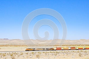 Colourful train locomotive going through desert