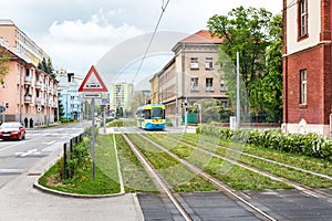 Barevná tramvaj jezdí na tramvajové trati přes zelenou travnatou plochu v Košicích SLOVENSKO