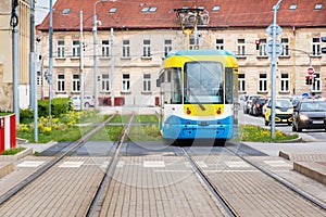 Colourful tram runs on tramway track over green grass area in Kosice SLOVAKIA