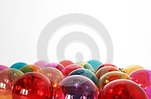 Colourful translucent glass Christmas baubles in whte isolated b
