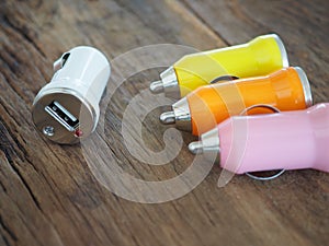 Colourful USB Car Charger on a wooden board with technology and energy concept