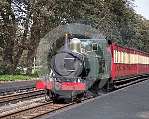 Colourful vintage steam loco Kissack approaching a station platform