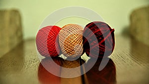 Colourful weaving cotton balls on a wooden surface