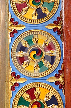 A colourful wheel and murals engraved on Shanti Stupa