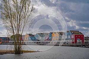 Colourful wooden lakeside houses De Rietplas. Modern residential architecture in Houten, The Netherlands