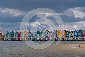 Colourful wooden lakeside houses De Rietplas. Modern residential architecture in Houten, The Netherlands