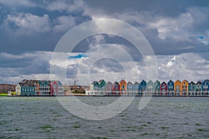 Colourful wooden lakeside houses De Rietplas. Modern residential architecture in Houten, The Netherlands