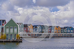 Colourful wooden lakeside houses De Rietplas. Modern residential architecture in Houten, The Netherlands