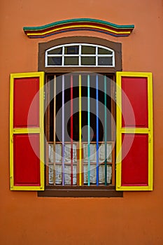 Colourful wooden window with grills