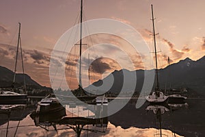 Colourful yachts docked at marina of Lecco town on spring sunset. Picturesque waterfront of Lecco located between famous Lake Como