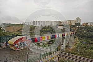 Colourfull train track through urban wasteland with apartment blocks