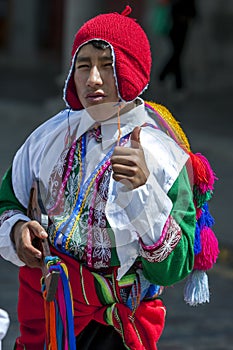 A colourfully dressed boy performs down a Cusco street during the May Day parade in Peru.