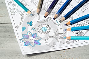 Colouring book for adults with blue coloured pencils, antistress painting