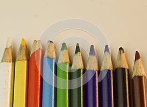 Colouring pencils lined up beside each other on white desk