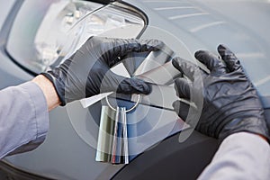 Colourist man selecting color of car with paint matching samples