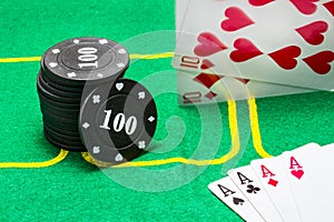 Column of black chips for poker falling cards and a combination of four aces