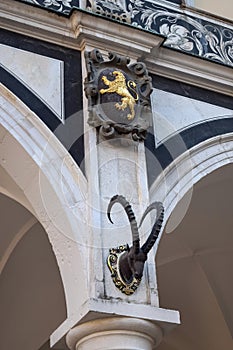 Column of a building with a golden lion and a deer head with antlers in Europe