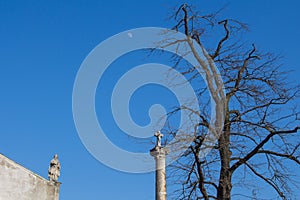 Stĺp s krížom, stromom, strechou a mesiacom