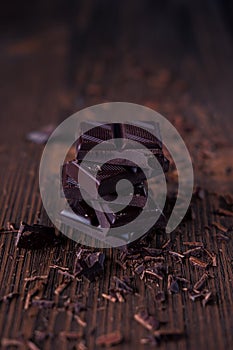 Column of dark or bitter or milk chocolate on a wood background