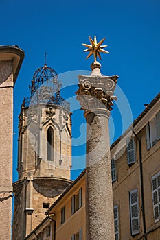 Column with golden star on top and bell tower in Aix-en-Provence.