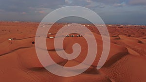 Column of jeeps travelling in sand desert