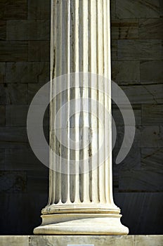 Column on marble background. Stone pillar on sunny outdoor. Architecture, structure and design. Support and decoration