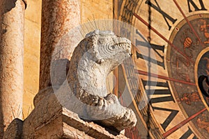 Column pier with lion sculpture and clock face of romanesque Duomo di Verona