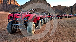 A column of red quads on a desert