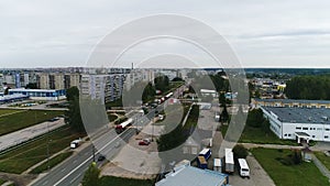 A column of trucks drives along the road on the outskirts of the city.