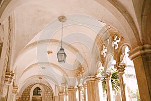 Columns and arches of a courtyard with a garden of the Dominican monastery in Dubrovnik, Croatia.