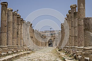 Columns in Colonnaded Street and North Gate at background, Ancient Roman city of Gerasa of Antiquity , modern Jerash, Jordan