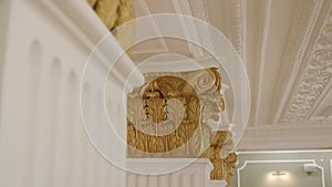 Columns with golden decor and surveillance camera in hall