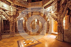 Columns with stone reliefs in Indian temple wall. Ancient architecture example with Jain motifs, Jaisalmer of India.