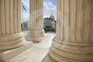 Columns of the Supreme Court with an American flag and the US Ca